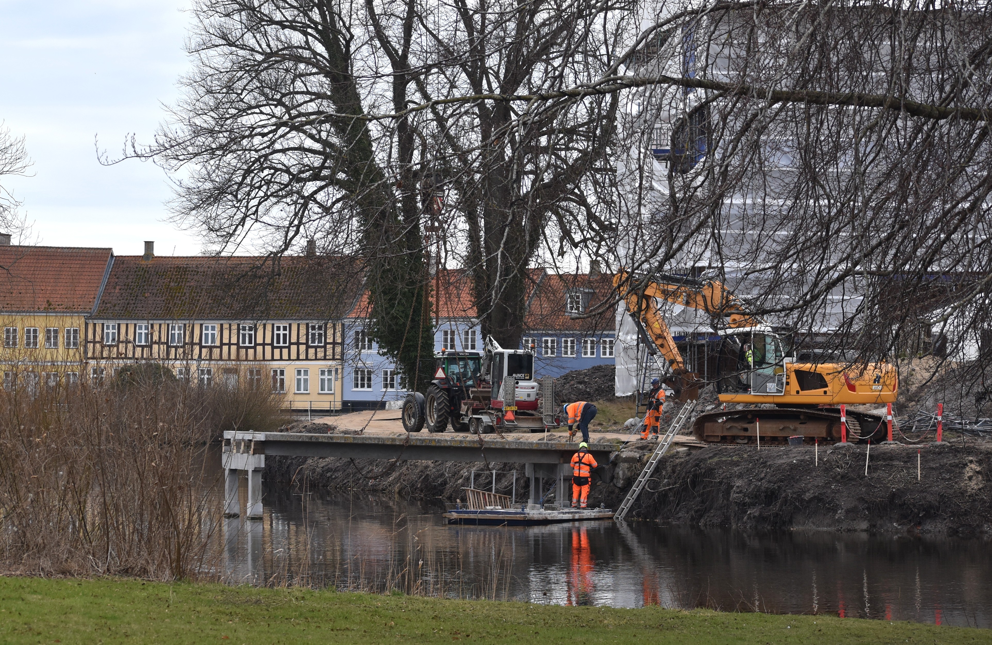 Arbejdsmænd på tømmerflåde i voldgraven der arbejder på at fjerne broen