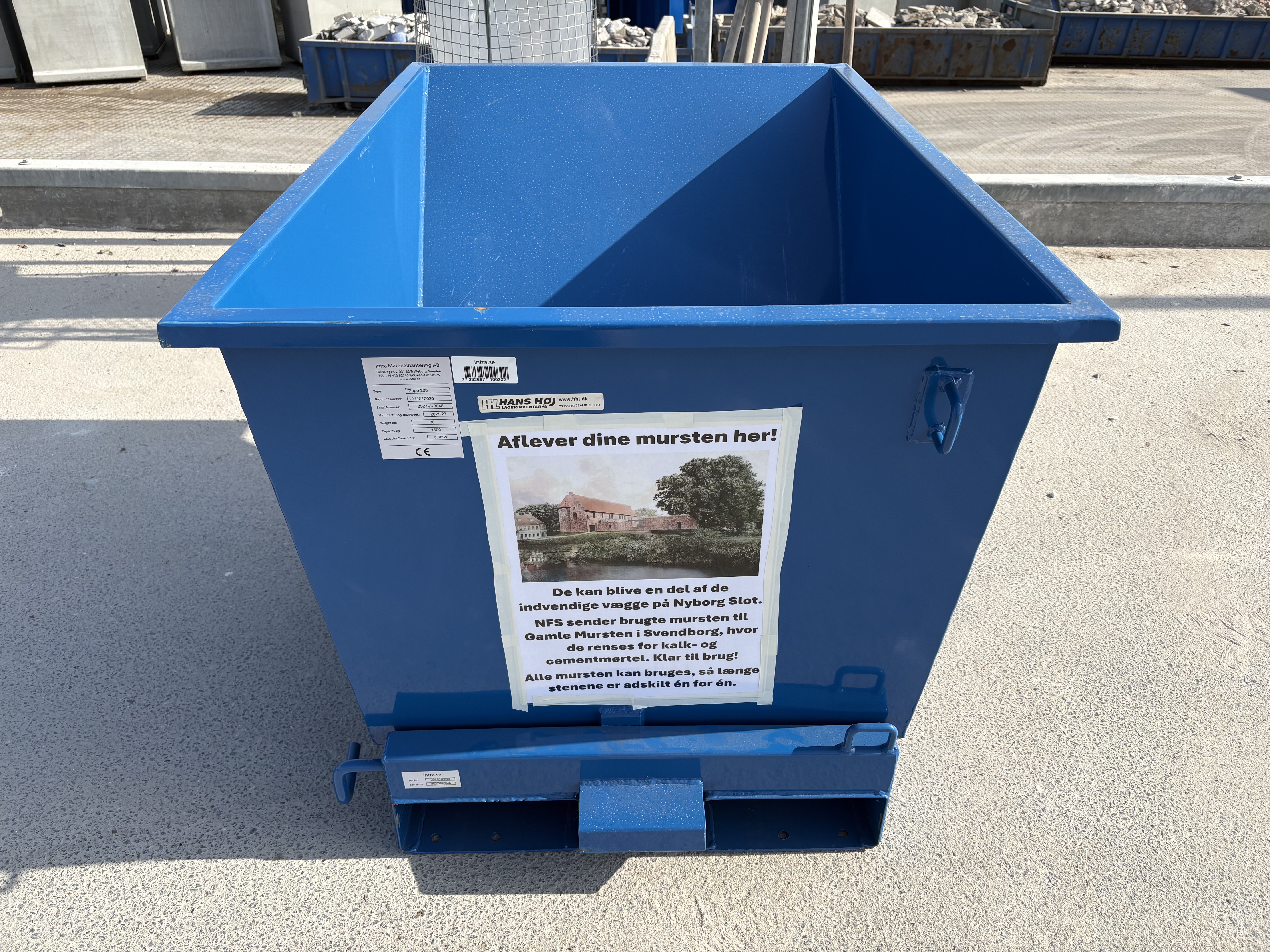 Plakat på container med ordlyden ' Aflever dine musten her!'