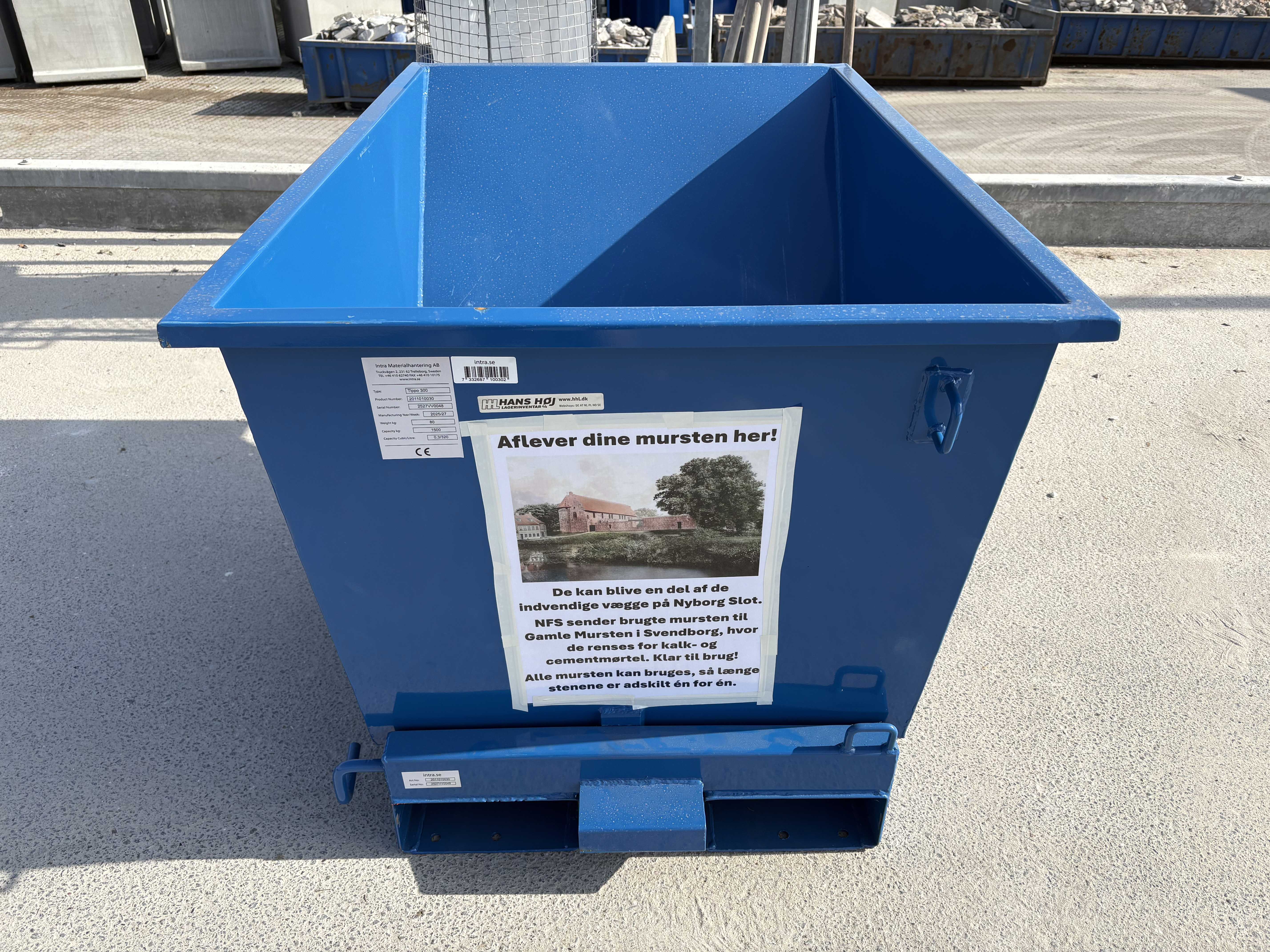 Plakat på container med ordlyden ' Aflever dine musten her!'