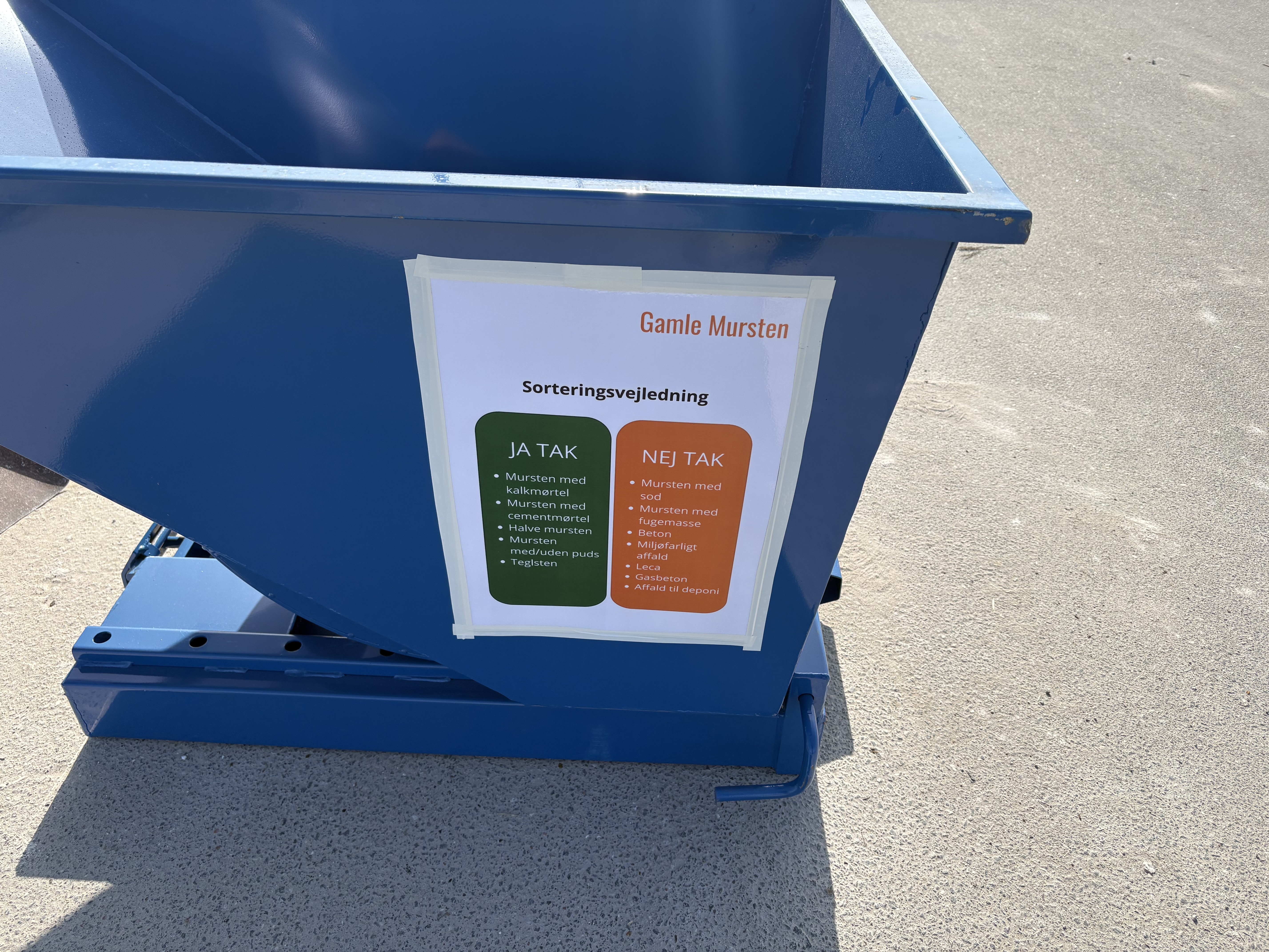 Container med plakate med ordlyden 'Sorteringsvejledning - gamle mursten'