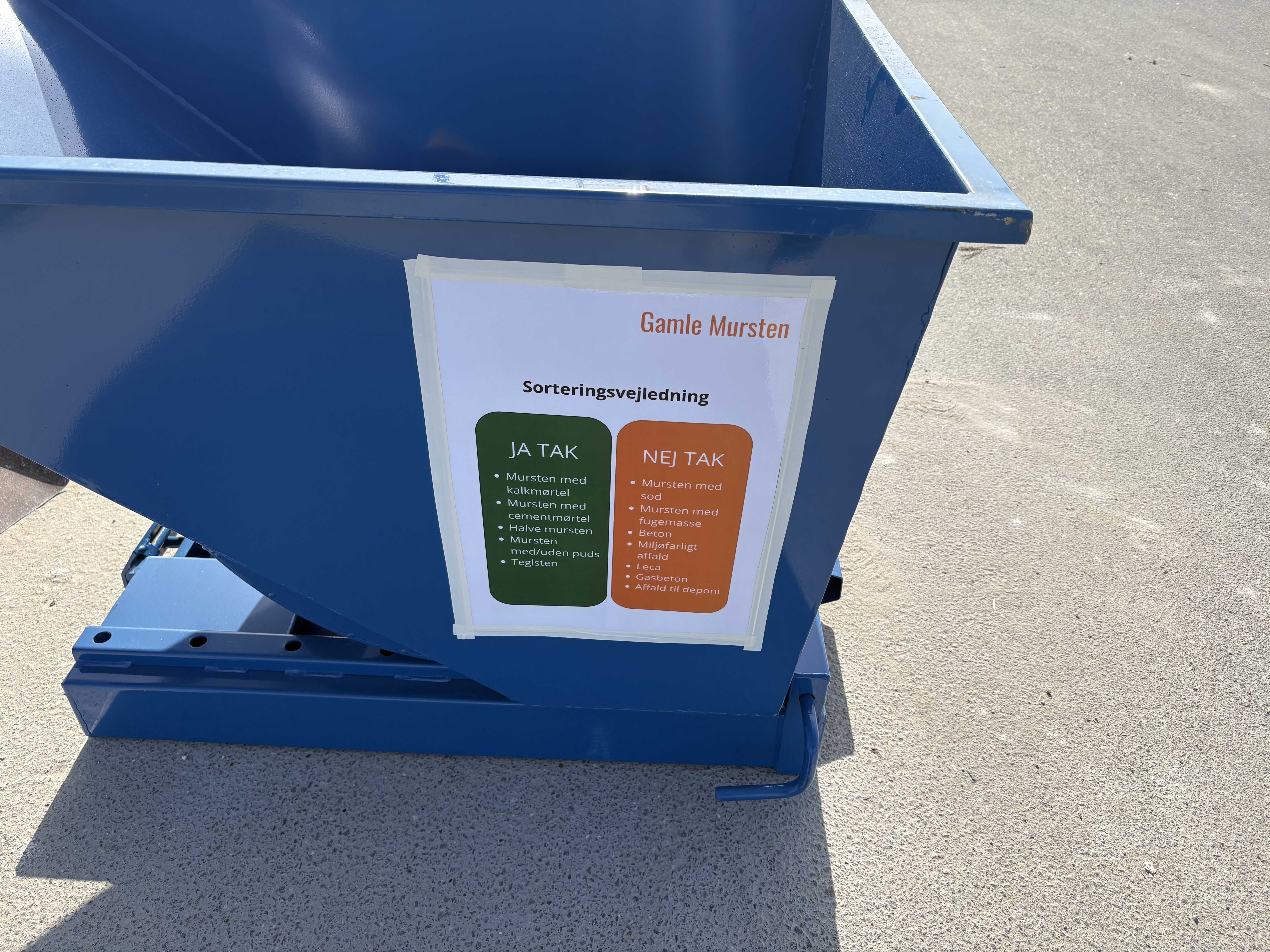 Container med plakate med ordlyden 'Sorteringsvejledning - gamle mursten'