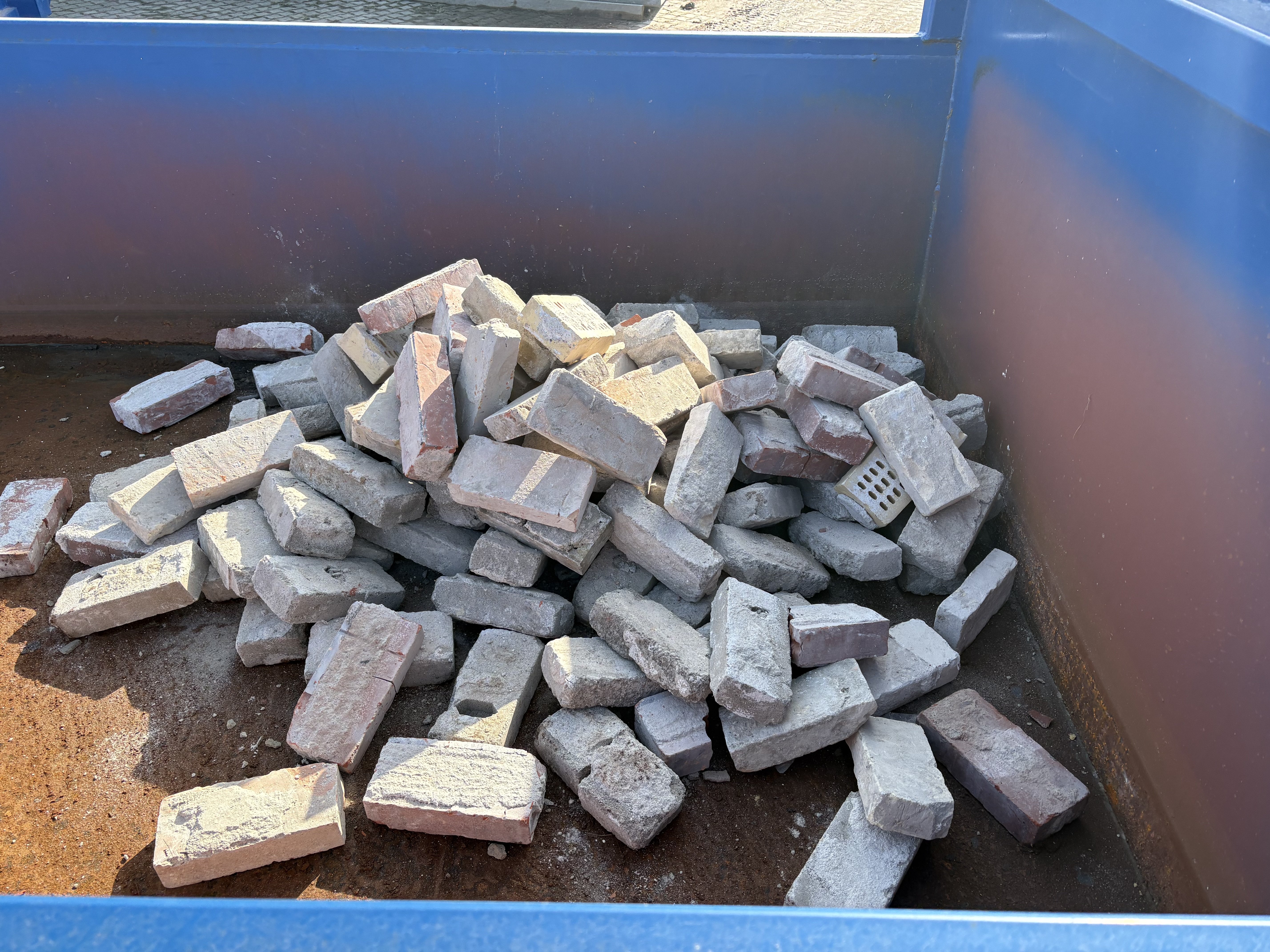 En masse brugte mursten i en container